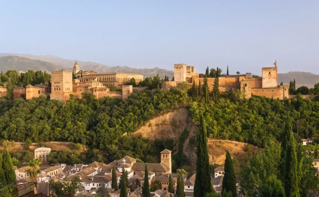 La Alhambra dorada al atardecer sobre las casas blancas del Albaicín, en Granada